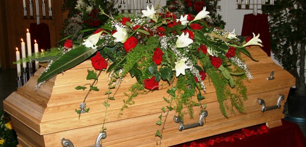Mit Rosen und Lilien geschmückter Sarg